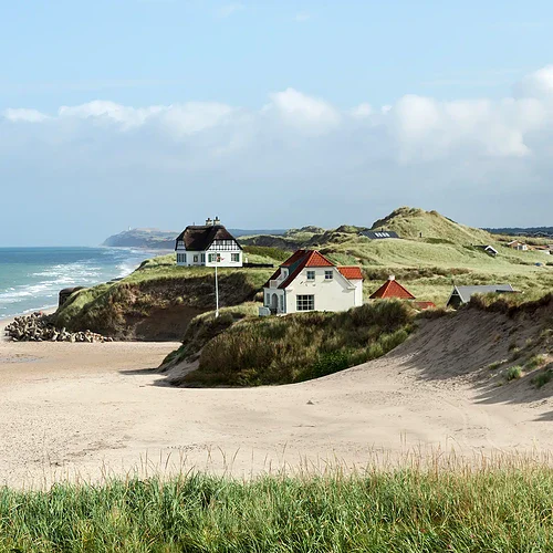 Vid kusten i Danmark med ett par som går på stranden