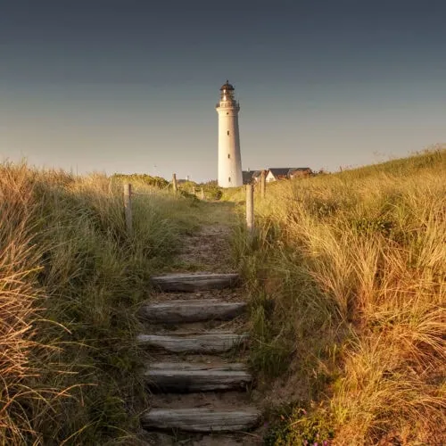 Ett fyrtorn i Danmark vid en strand