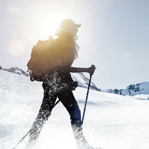 En kvinna på skidor som går i Italienska alperna