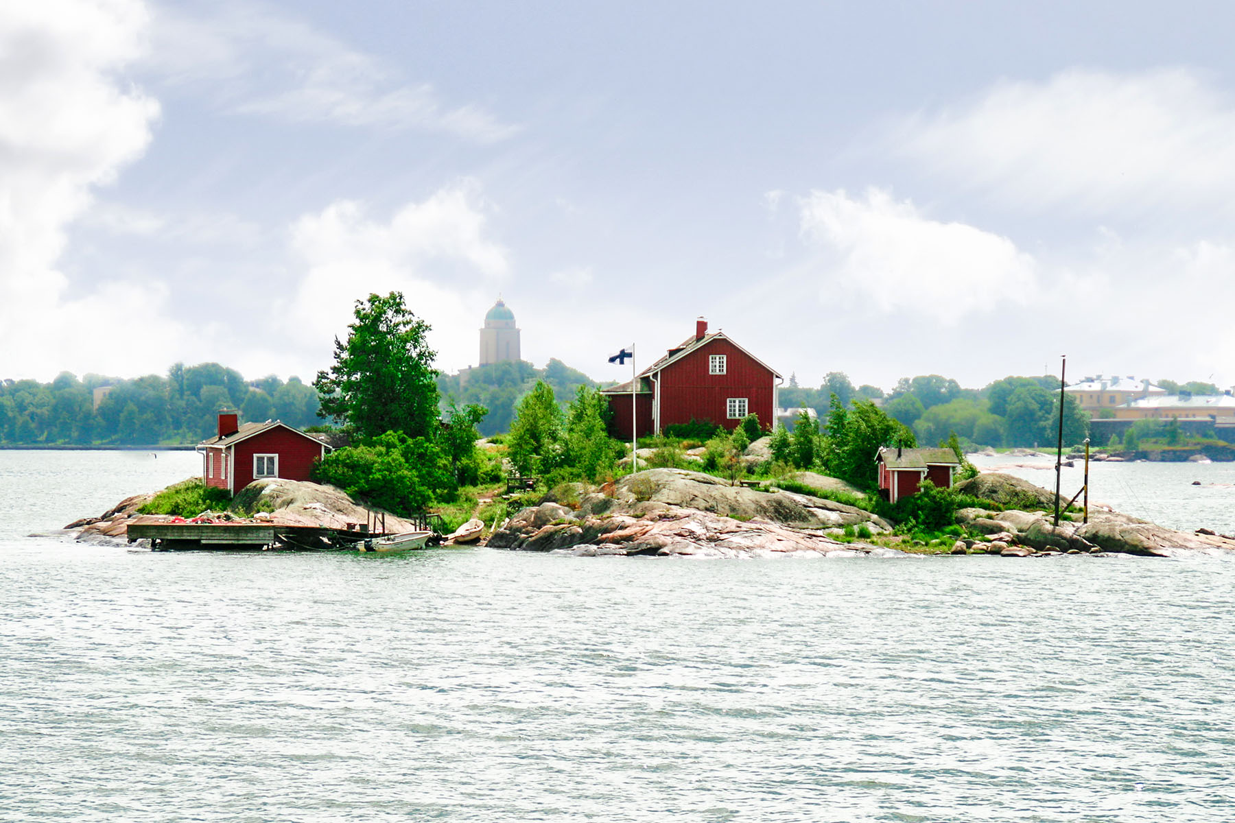 en röd stuga på en ö i Finlands skärgår