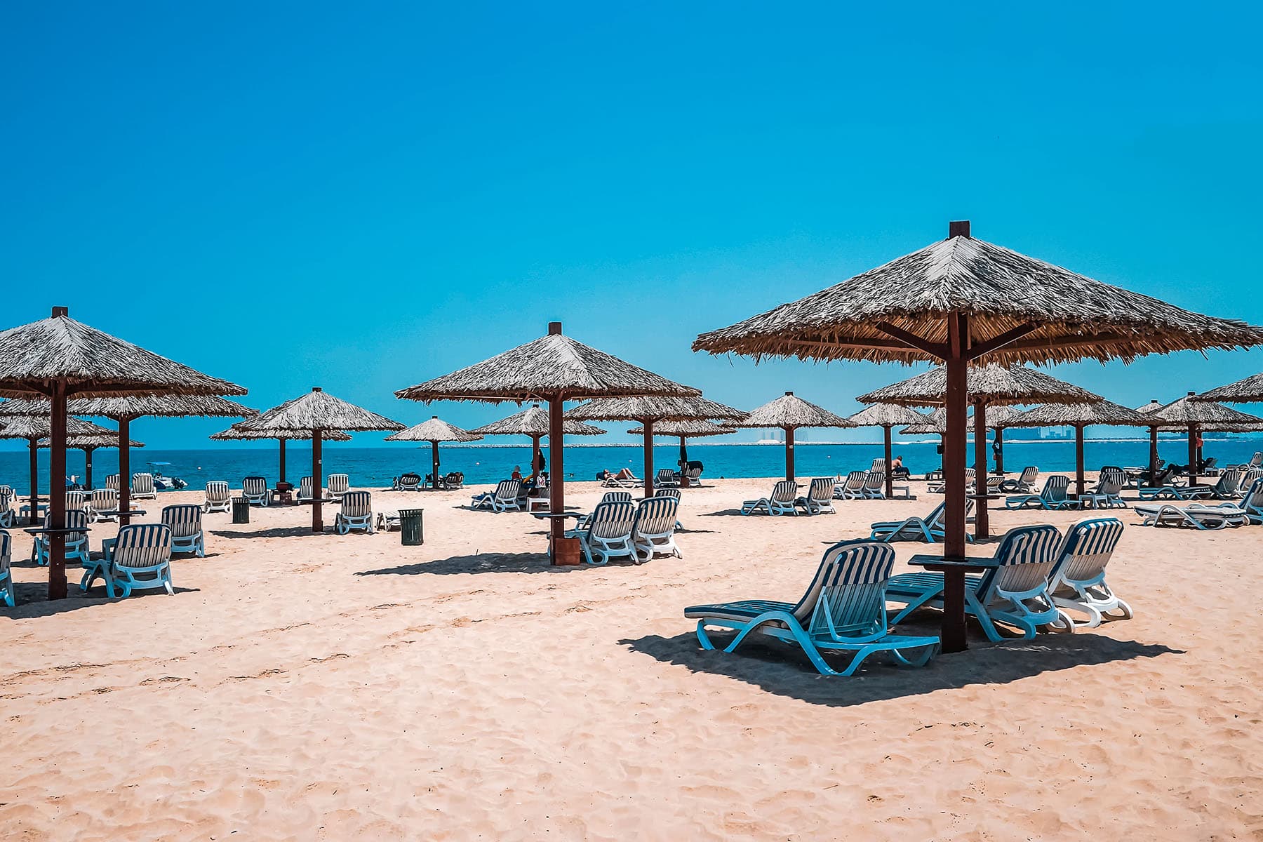 En strand med solstolar och parasoller i Förenade Arab Emiraten