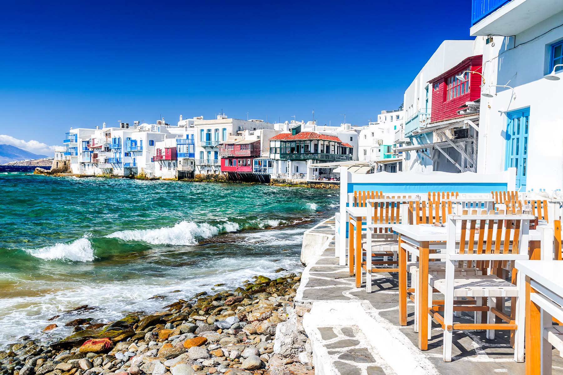 en vit by på Mykonos i Grekland med en restaurang  vid havet
