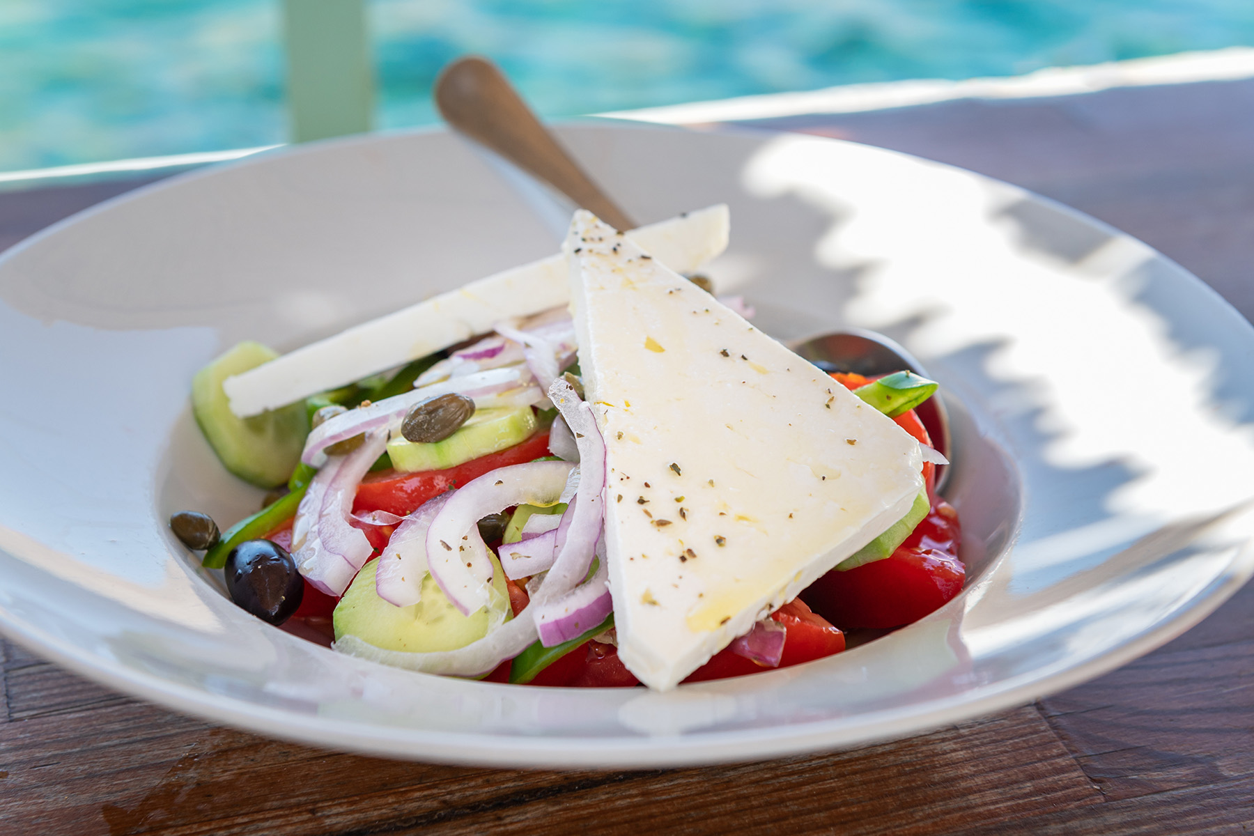 en tallrik med grekisk sallad med fetaost på toppen