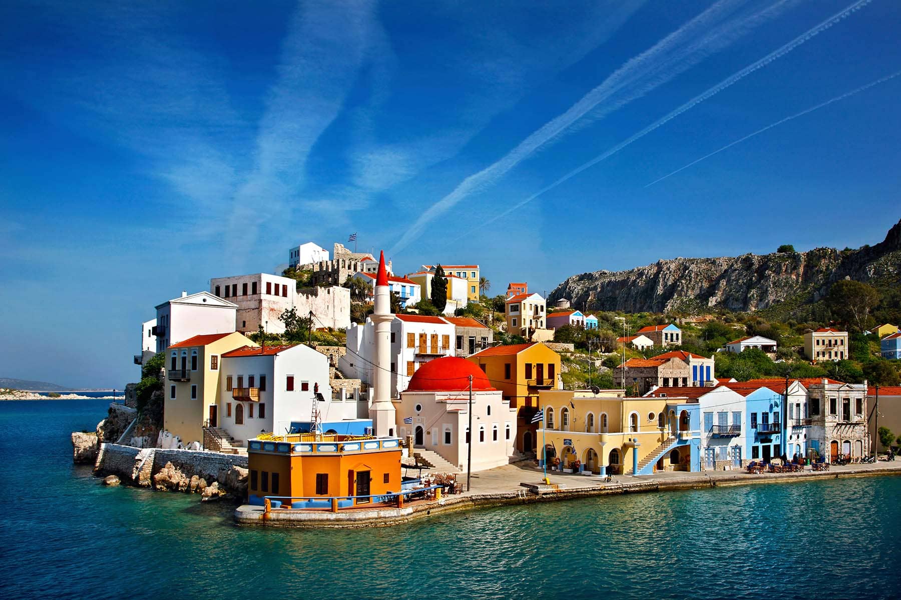 en Grekisk by med färgrika hus vid havet