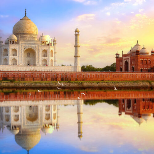 Taj Mahal med en byggnad bredvid som speglar sig i vattnet