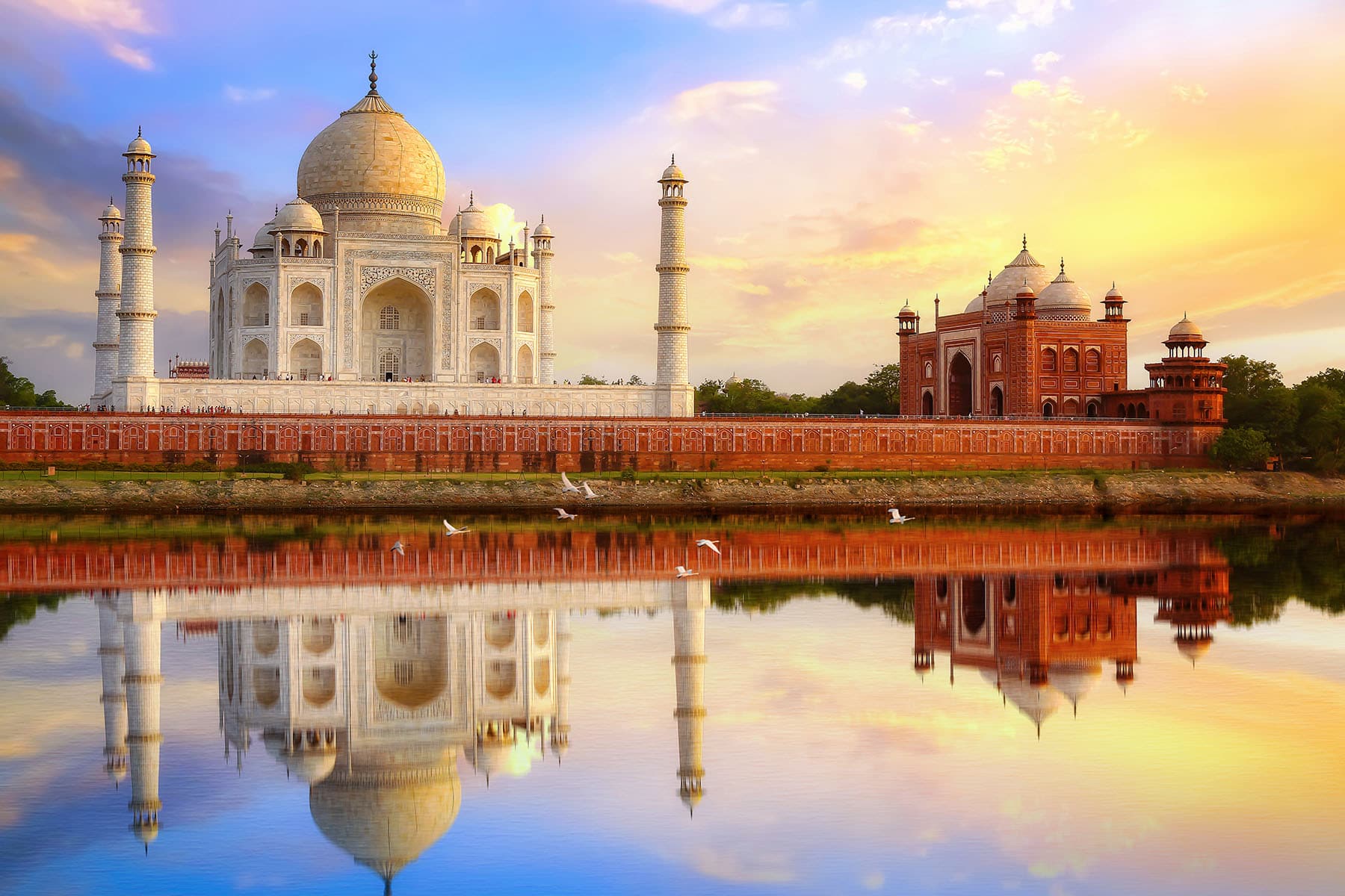 Taj Mahal med en byggnad bredvid som speglar sig i vattnet