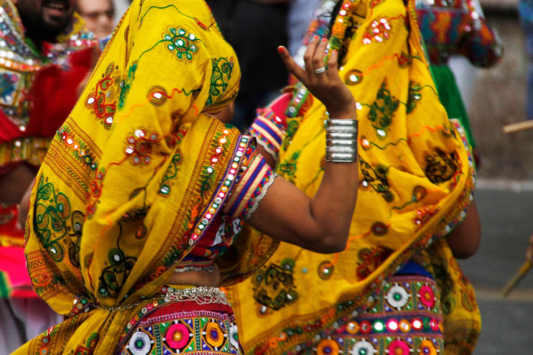 Indiska kvinnor dansar i vackra och färgrika tyg i i Indien