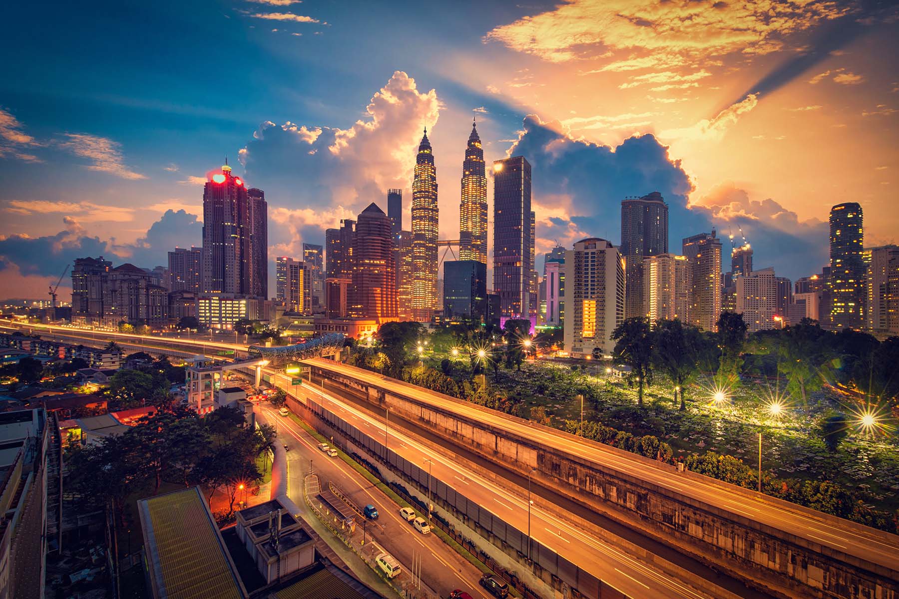 Vacker kvällsbild av Kuala Lumpurs skyline med Petronas Twin Towers och moderna skyskrapor i skymningen, ljus och liv i stadsbilden.