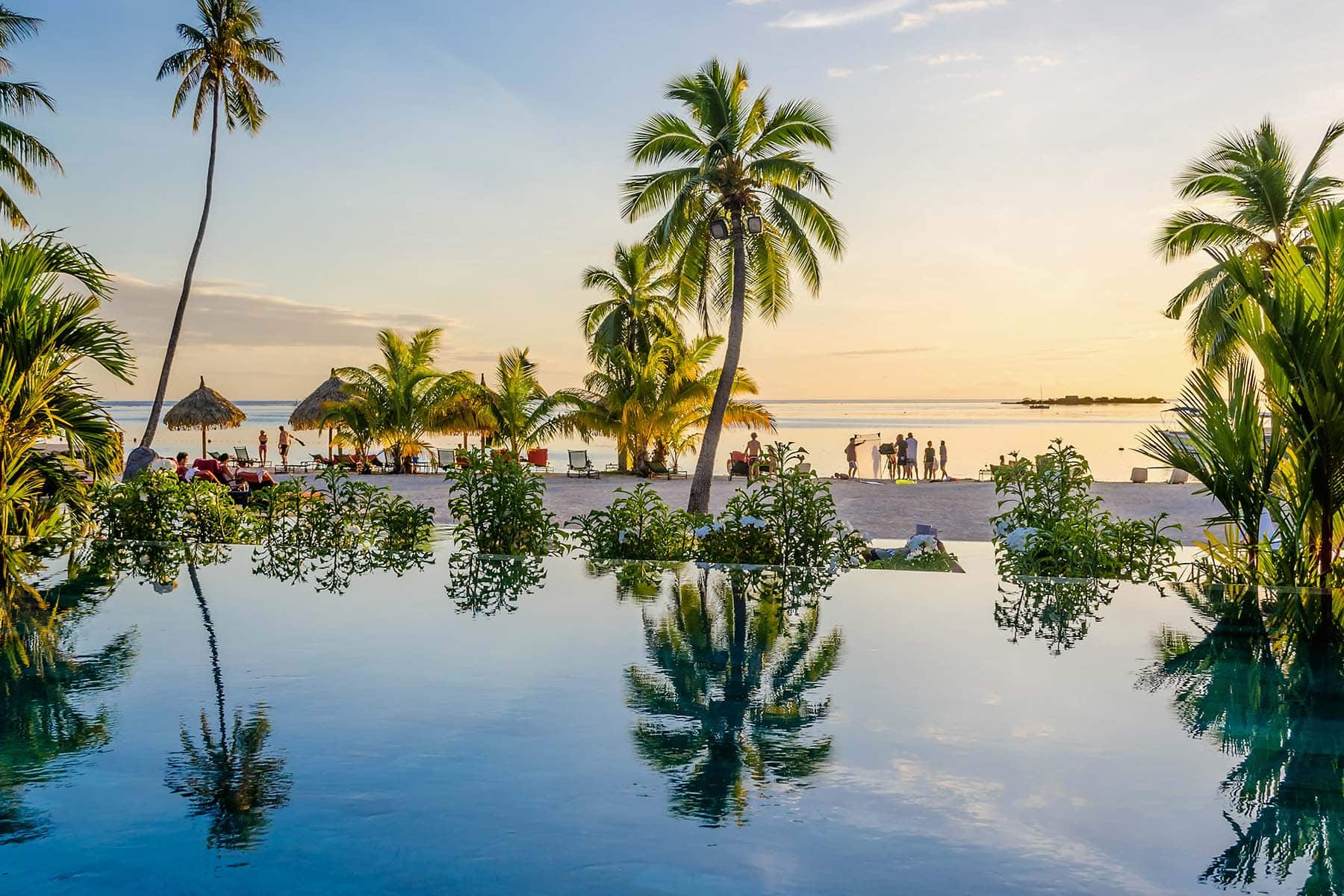 en pool med strand och människor i bakgrunden