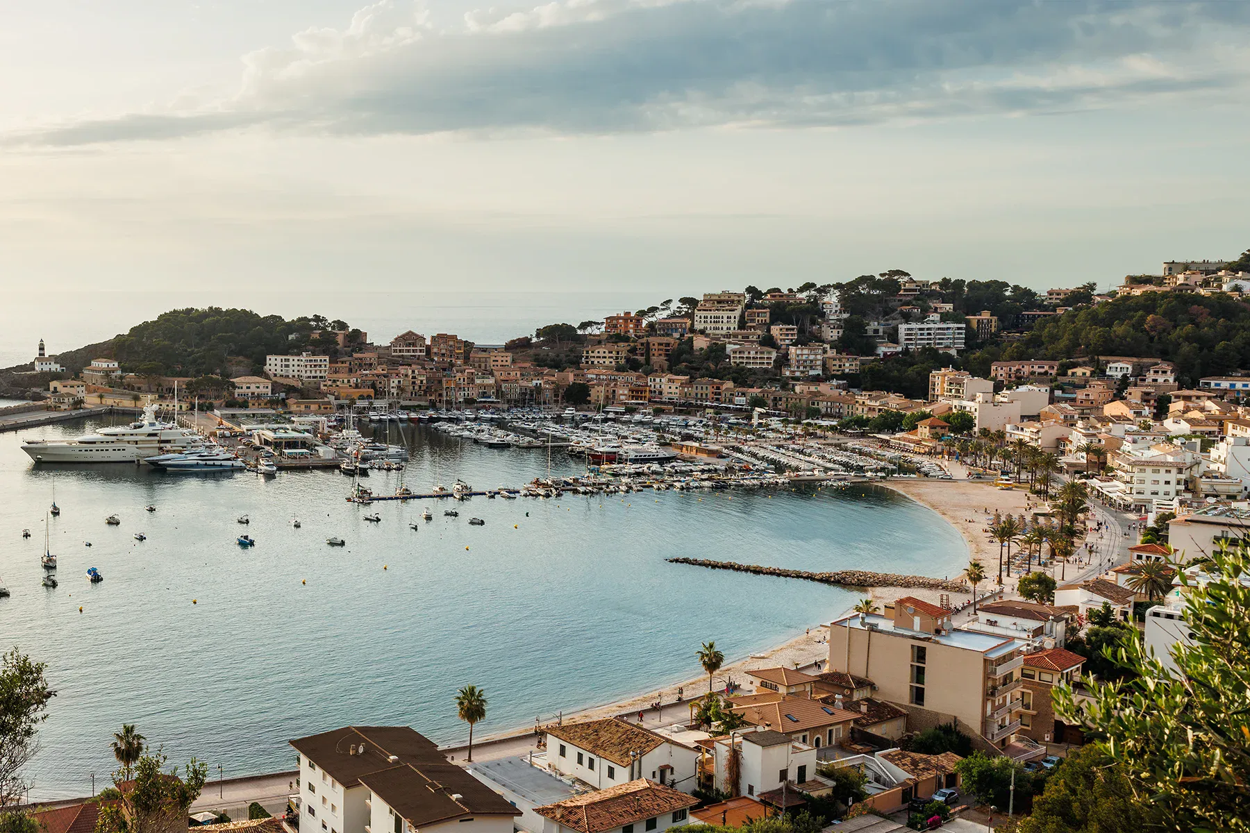 Vacker vy över en mysig hamn på Mallorca med båtar och kustnära byggnader.