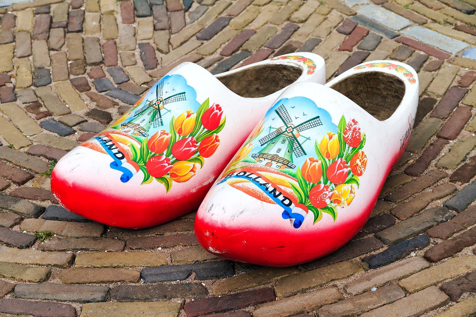 Två träskor med målade tulpaner och väderkvarn i Nederländerna