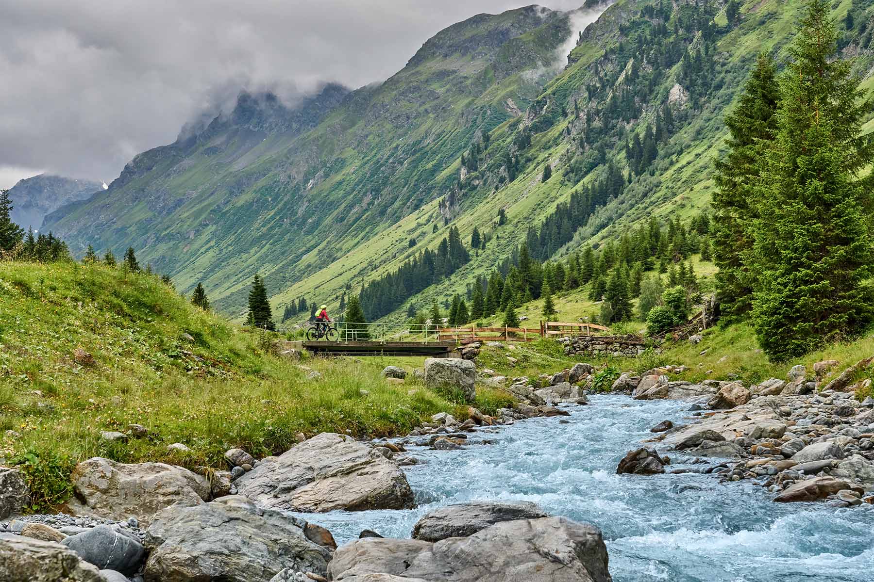en cyklist som cyklar över en bro i vacker natur i Österrike