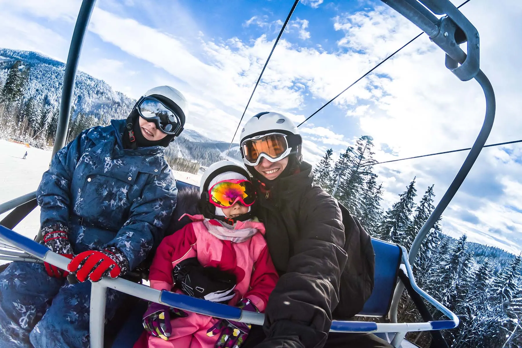 en glad familj som sitter i en lift i Österrikes alper