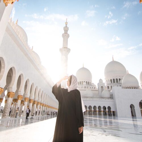 Bild av Sheikh Zayed-moskén i Ras al Khaimah, med vit arkitektur och kupoler under en klar himmel.