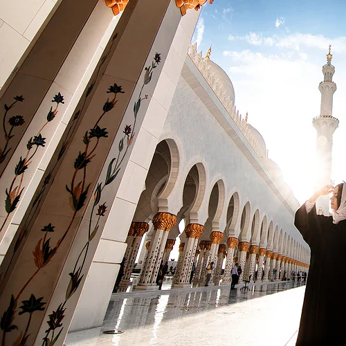 En kvinna framför en moske i Ras al Khaimah, Förenade Arabemiraten