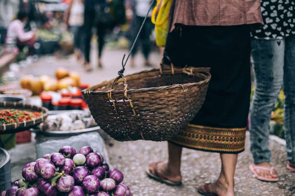 En thailändska med en korg på en marknad i Chiang Mai