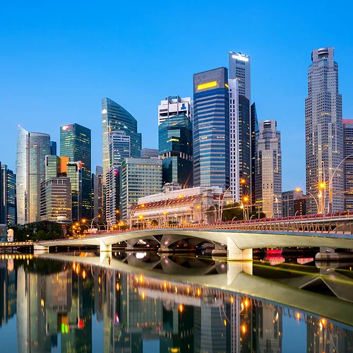 Moderna Singapore-skyline med skyskrapor och vattnet vid skymningen.