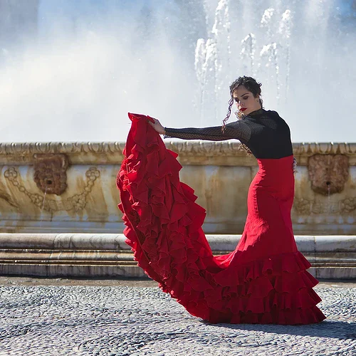 En spanjorska som dansar Flamenco framför en fontän i Spanien