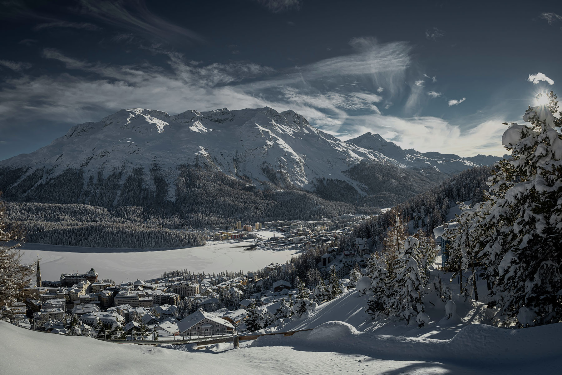 staden St. Moritz vid foten av snöklädda alper