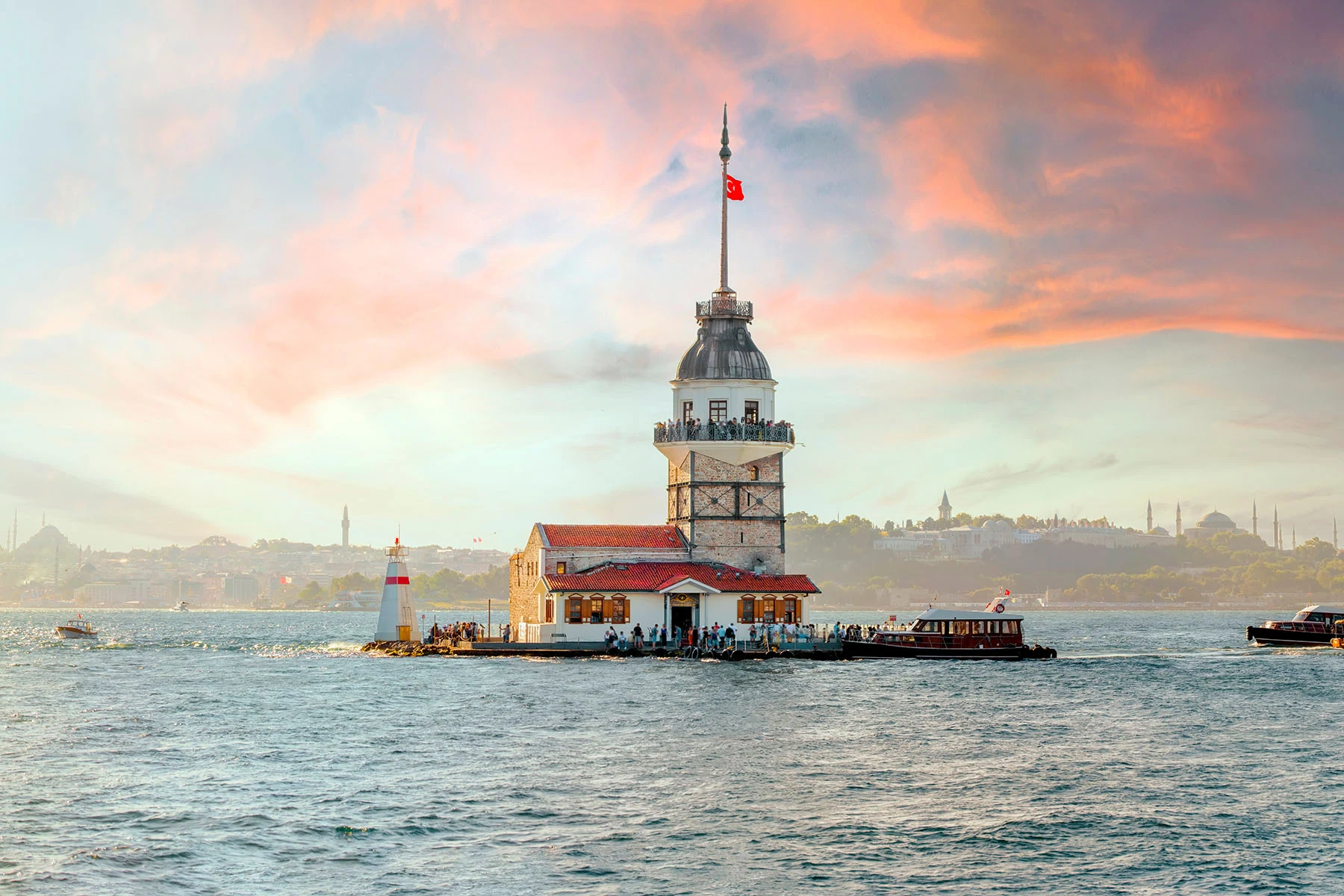 ett fyrtorn ute i havet i Turkiet med båtar som ligger vid bryggan