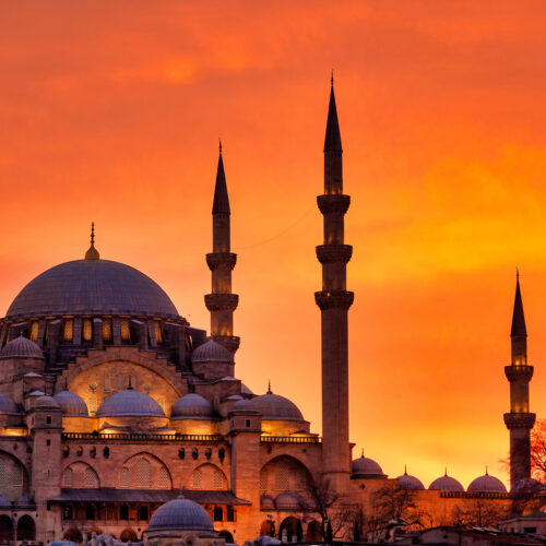 tornen på en Moské i Turkiet med en röd himmel i bakgrunden