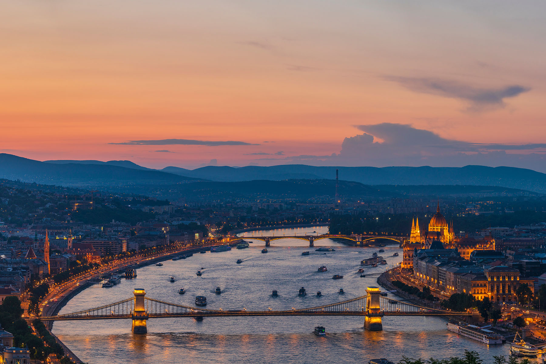 en älv i Ungern med en bro och båtar